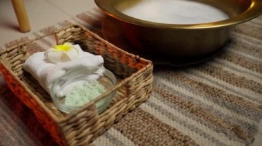 Masaj salonunu kapatın. Masaj öncesi ayak yıkama prosedürü. Hasır hasır, sabun solüsyonu sepeti, fırça ve havlu.