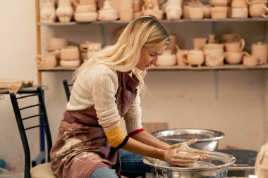 Çamur modelleme stüdyosunda genç kız elleri çömlekçi çarkında kil şekillendiriyor. Eski sanat eseri.