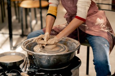 Çamur modelleme stüdyosunda genç kız elleri çömlekçi çarkında kil şekillendiriyor. Eski sanat eseri.