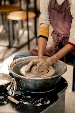 Çamur modelleme stüdyosunda genç kız elleri çömlekçi çarkında kil şekillendiriyor. Eski sanat eseri.