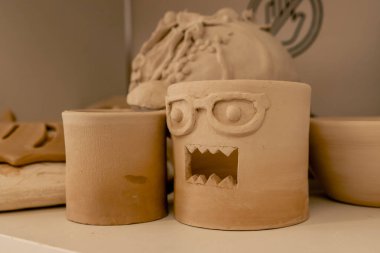 Bir mankenlik stüdyosuna yakın çekim. Tamamlanmış kil çömlek ve dekorasyondan oluşan bir dağ. Kovmadan ve dekorasyondan önce kurulanıyor.