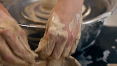 Kil modelleme stüdyosuna yakın genç kız elleri çömlekçi çarkında kil şekillendiriyor eski sanat eserlerini uyguluyor.