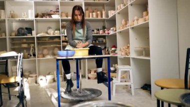 Kil modelleme stüdyosunda genç kız elleri çömlekçi çarkında kil şekillendiriyor eski el işi mekanik çömlekçiler tekerleği