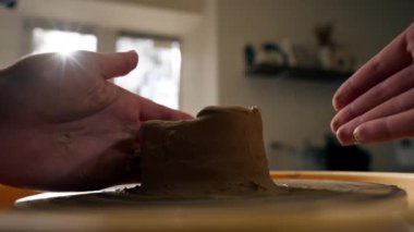 Kil modelleme stüdyosuna yakın genç kız elleri çömlekçi çarkında kil şekillendiriyor eski sanat eserlerini uyguluyor.