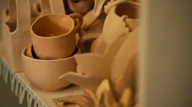 Bir mankenlik stüdyosuna yakın çekim. Tamamlanmış kil çömlek ve dekorasyondan oluşan bir dağ. Kovmadan ve dekorasyondan önce kurulanıyor.