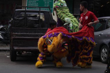 Solo, Endonezya, 2 Mart 2018. Solo sokaklarında bir çocuk barangay kostümü giyiyor. Bu Çin Yeni Yıl numaraları ile yapılır..