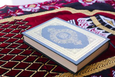 El-Kuran ve namaz paspasları Müslümanlar için ibadet araçlarıdır.