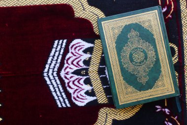 El-Kuran ve namaz paspasları Müslümanlar için ibadet araçlarıdır.