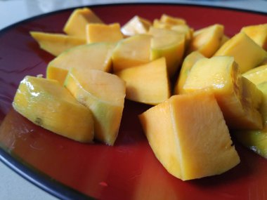 Soyulmuş mangolar ve plastik kaplara konmuş.