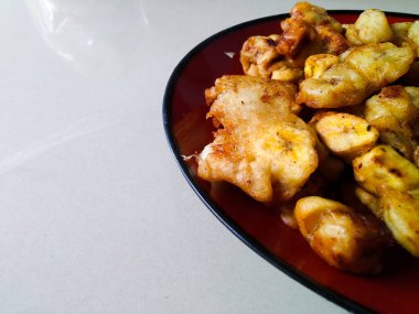 Kırmızı tabakta kızarmış muz tabağı.