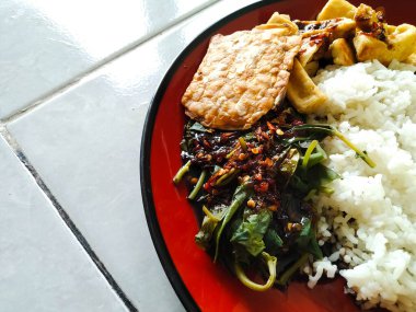 Kahvaltı menüsü sebzeli pilav, kızarmış tofu ve kızarmış tempeh.