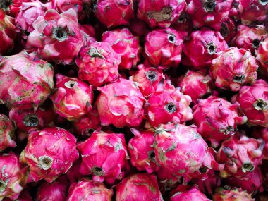 Rafta sergilenen ejderha meyvelerini istifleyin.