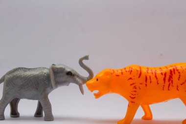 Beyaz arka planda kaplan ve fil şeklinde bebekler.