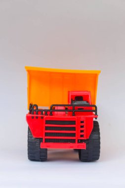 Beyaz arka planda kırmızı ve sarı kamyonet oyuncağı