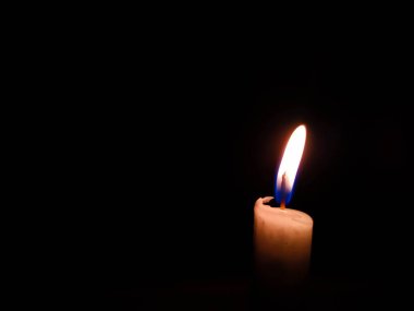 Karanlık odanın ortasında mumlar yanıyor.