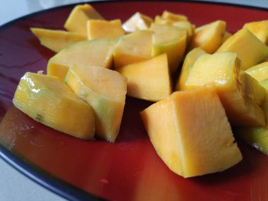 Soyulmuş mangolar ve plastik kaplara konmuş.