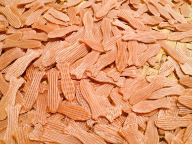 Pink crackers in the shape of fish being dried in the sun clipart