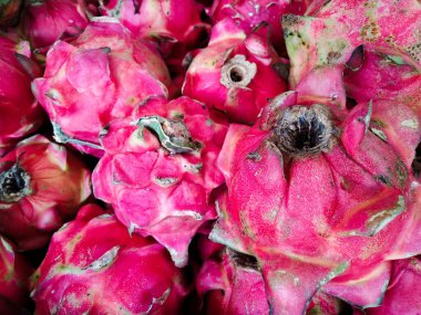 Rafta sergilenen ejderha meyvelerini istifleyin.