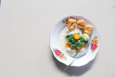 Breakfast menu of vegetable rice with fried tofu as a side dish clipart