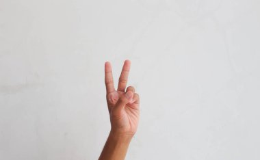 Bir adamın eli iki parmağını gösterir.