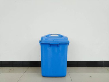 Duvarın yanına konmuş bir çöp kutusu.