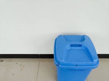 Duvarın yanına konmuş bir çöp kutusu.