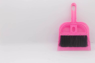Beyaz arkaplanda küçük pembe süpürge