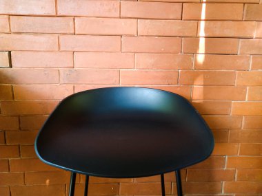 Kırmızı tuğlalı siyah koltuk.