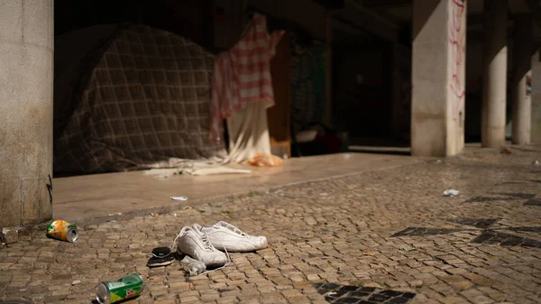 Kirli bir sokakta bir çift yıpranmış ayakkabı.