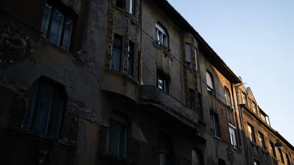 Old flats and neighboring windows against the sunset in the city