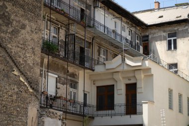 Evleri ve balkonları olan eski ve yıpranmış bir binanın arka bahçesi.