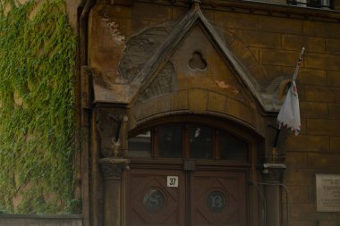 Eski bir binanın tepesinde, yanında yeşil bir şey var.