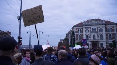 Birçok insan ellerinde işaretlerle protesto ediyor.