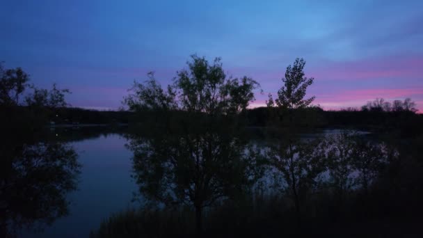 夕暮れ時のピンク色の空と空からの釣りの湖 — ストック動画