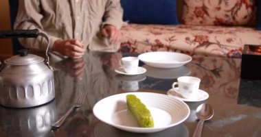 Table ready for dinner with a teapot and plates on