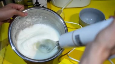 Pure white cream whipping by a hand mixer