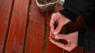 Angler putting groundbait into a feeder basket