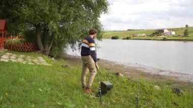 Moment of angler catching a fish while preparing the other rod