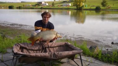 Angler holding out a carp proudly