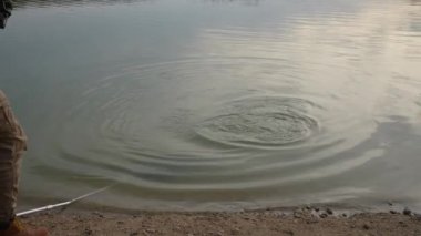 Angler fighting a fish which comes up near surface