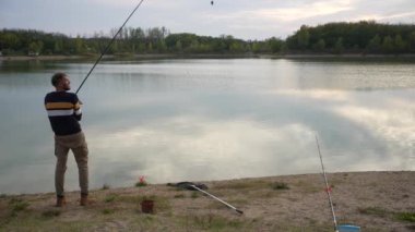 Angler walking down the lakeside to cast out his line