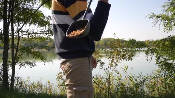 Man Throwing Some Corn Water — Vídeos de Stock