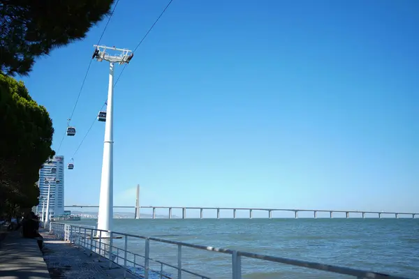 cable lift cabins above the sea and a distant bridge