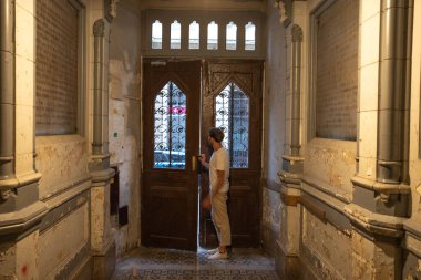 Guy peeking out a big entrance door