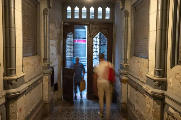 People coming in and leaving a building