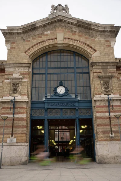 Two cyclists passing in front of a building