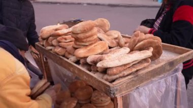 Arabic street vendor selling bread to a woman