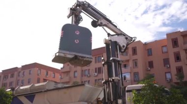 Waste collecting truck putting down a big rubbish container