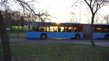 Mavi otobüs gün batımında geçiyor. Yüksek kalite 4k görüntü