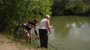 Oğlu babasına balık tutmasında yardım ediyor. Yüksek kaliteli FullHD görüntüler